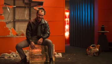 The only way Dom Hemingway knows how to make an entrance: Through the damn wall.
